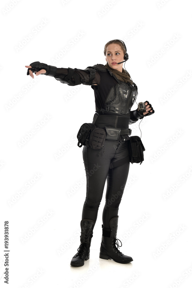 full length portrait of female soldier wearing black tactical armour holding a pair of binoculars, isolated on white studio background. full length portrait of female soldier wearing black tactical armour holding a pair of binoculars, isolated on white studio background.