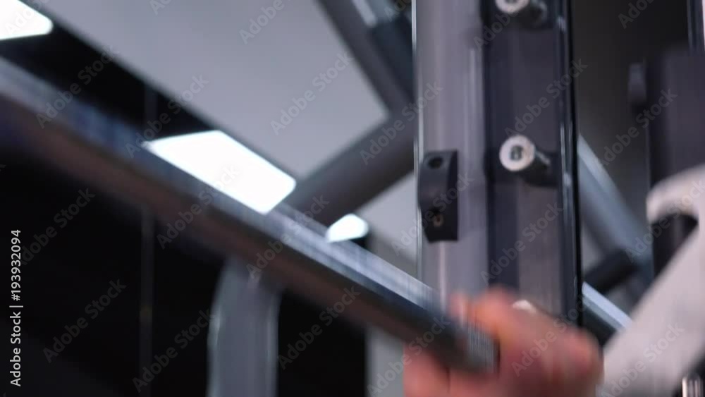 A fit man does inclined bench press in a gym - closeup A fit man does inclined bench press in a gym - closeup