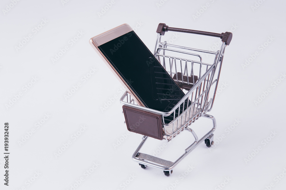 A shopping cart with smartphone inside, indicating mobile commerce and e-commerce A shopping cart with smartphone inside, indicating mobile commerce and e-commerce