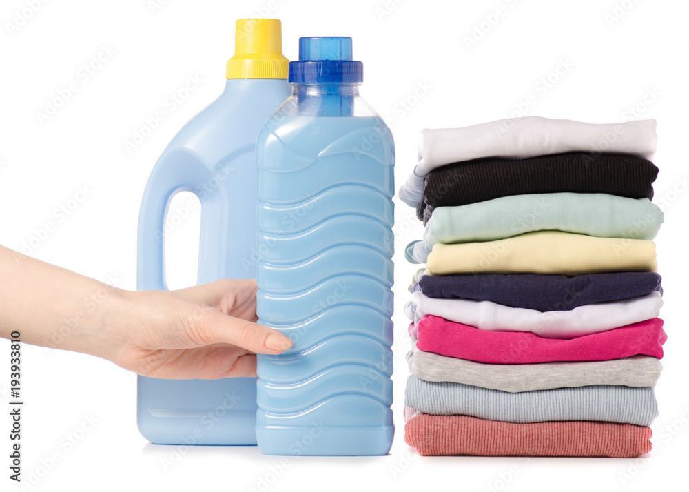 Stack of clothes Liquid powder conditioner fabric softener in hand Stack of clothes Liquid powder conditioner fabric softener in hand