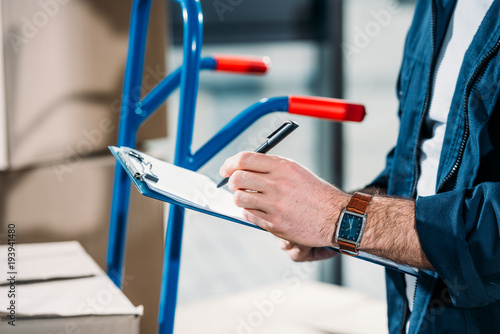 Close-up view of delivery man filling cargo declaration © LIGHTFIELD STUDIOS