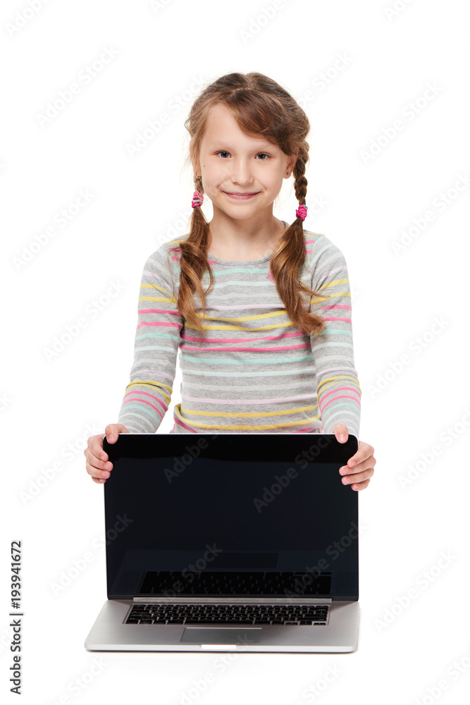Smiling little girl sitting on the floor with laptop, showing blank black screen, over white background Smiling little girl sitting on the floor with laptop, showing blank black screen, over white background