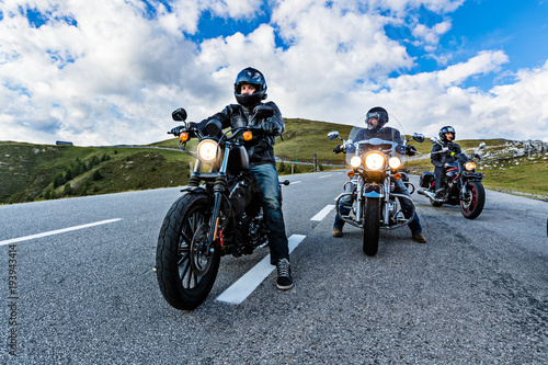 Fotografia Motorcycle drivers riding in Alpine highway, Nockalmstrasse, Austria, Europe