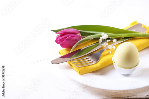 Easter laying table appointments, table setting options. Silverware, tableware items with festive decoration. Fork, knife and flowers. Happy easter holiday. photo