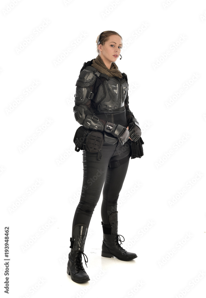 full length portrait of female  soldier wearing black  tactical armour, isolated on white studio background.