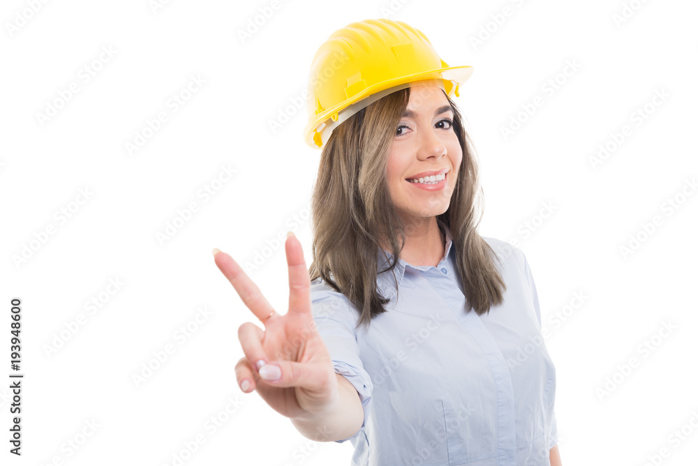 Portrait of female constructor showing peace gesture.