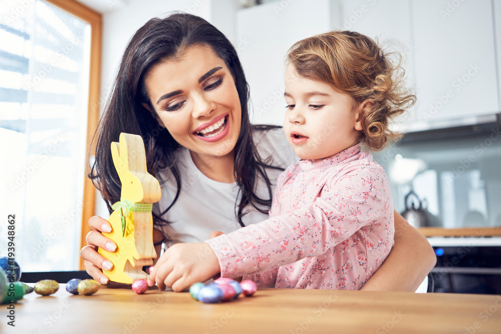 Fototapeta premium Mother and child having fun playing with wooden easter bunny.