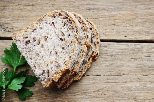 Wholegrain bread in slices isolated on rustic wooden background 