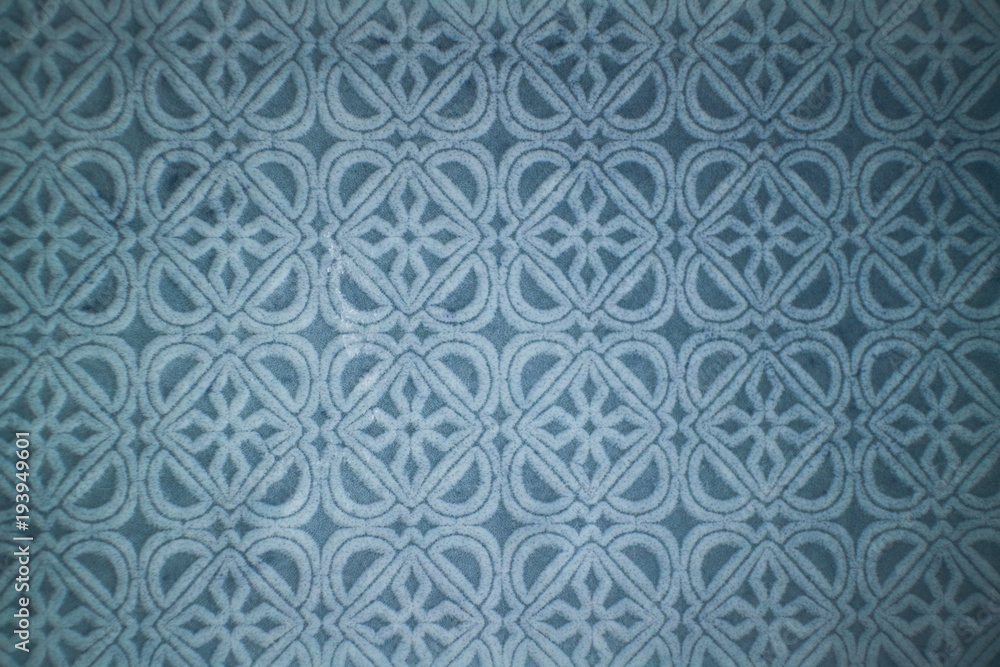 Ceramic blue tile with decorative pattern.