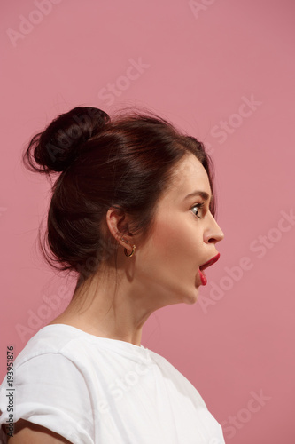 Beautiful woman looking suprised isolated on pink