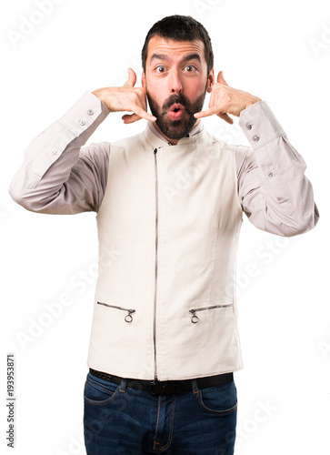 Handsome man with vest making phone gesture on isolated white background