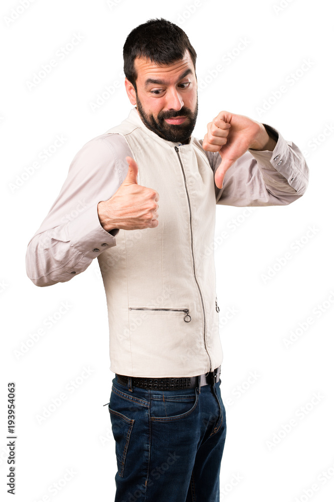 Handsome man with vest making good-bad sign on isolated white background Handsome man with vest making good-bad sign on isolated white background