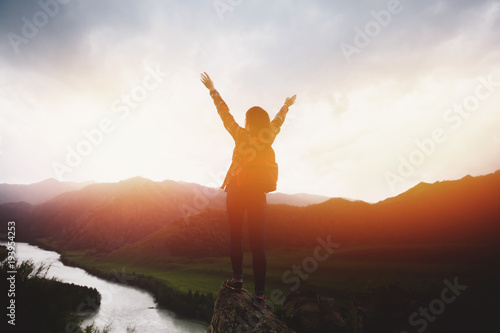 Traveling woman with backpack looking river and mountains, sunny day