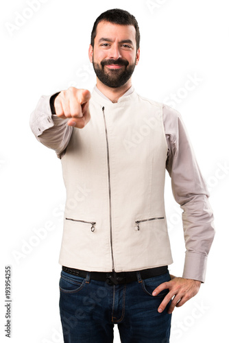 Handsome man with vest pointing to the front on isolated white background