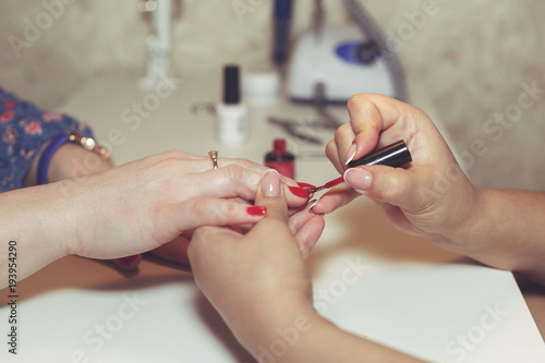 Woman doing manicure in beauty salon.