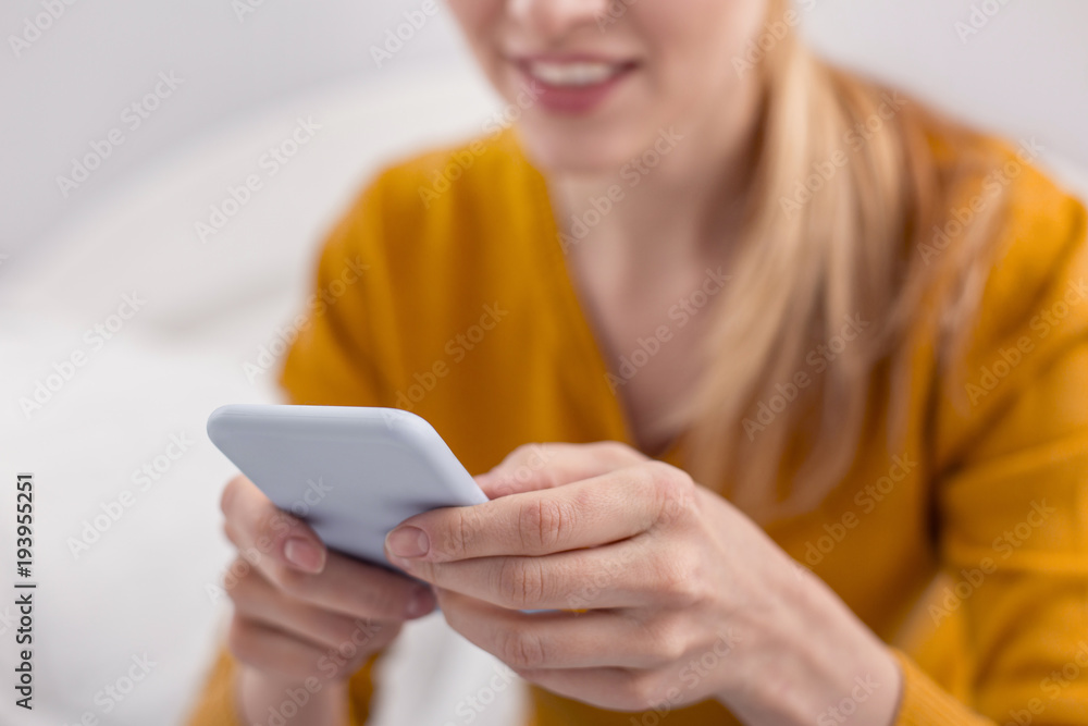 Advanced smartphone. Selective focus of female young hands using phone while taking it with both hands Advanced smartphone. Selective focus of female young hands using phone while taking it with both hands