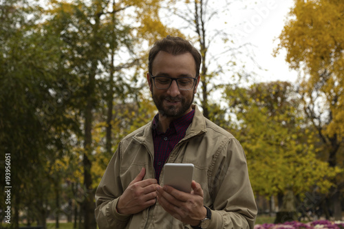 Modern guy using smart phone in the European city.