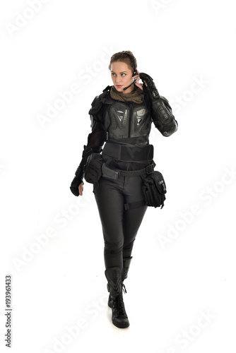 full length portrait of female  soldier wearing black  tactical armour, isolated on white studio background. © faestock