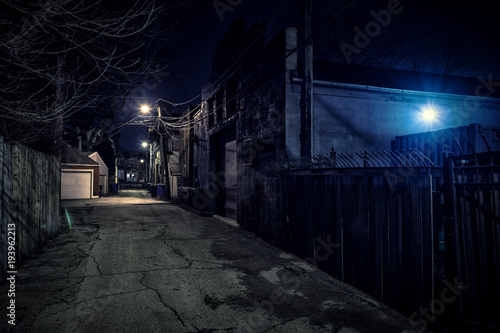 Dark empty scary urban city street alley with vintage buildings at night
