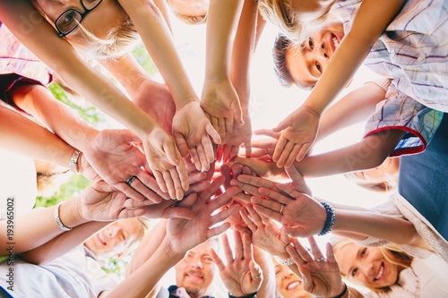 Close-up of happy people heaping hands in summer