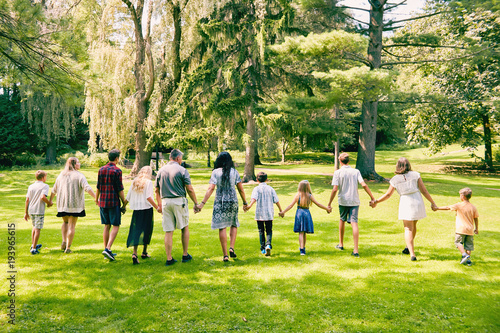 Rear view of family of eleven walking in park