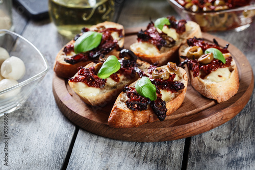 Appetizer bruschetta with sun-dried tomatoes  olives and mozarella.