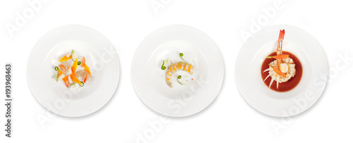 Three plates of culinary dishes with sea food shrimps and gamba on a white background