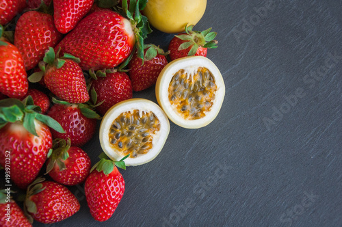 Fresh strawberries and passion fruit on a gray background with copy space