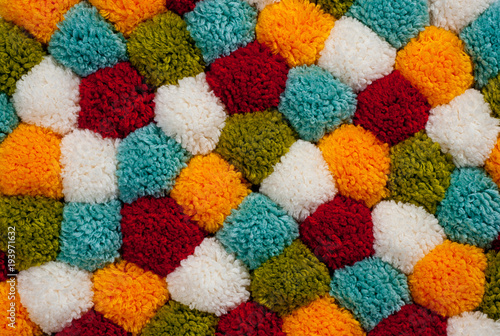 Mat of pompons made from multi-colored handmade yarn © Pavlo