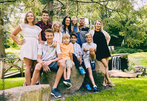 Happy family of eleven posing together in park