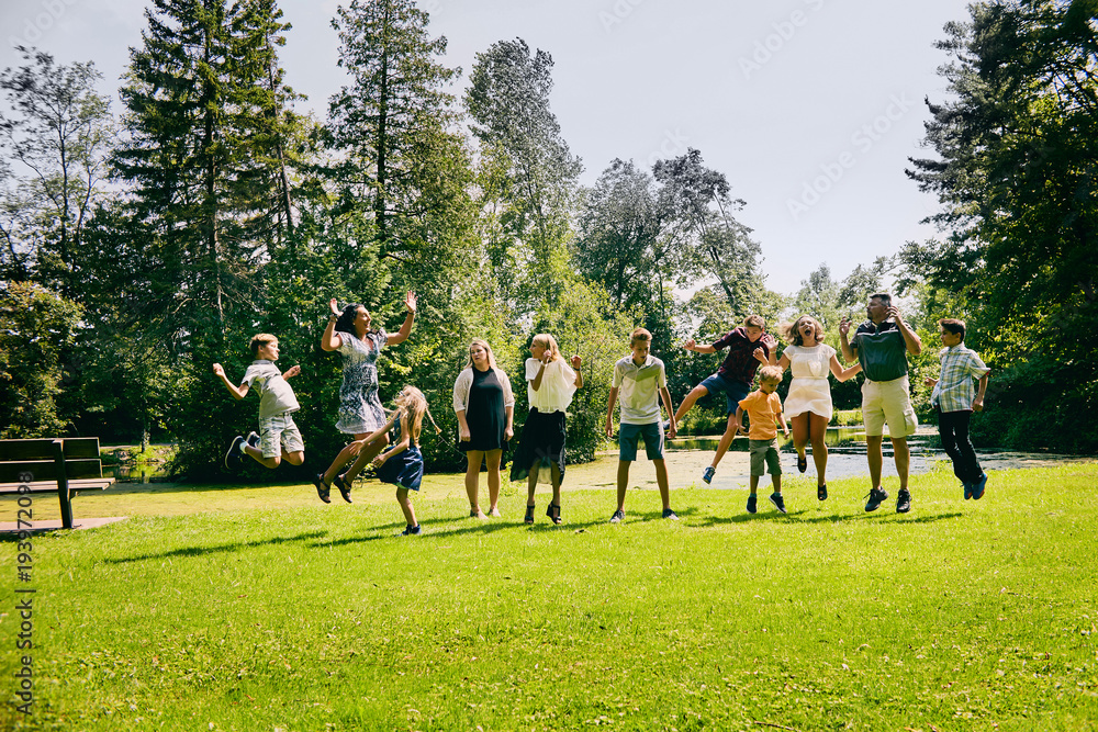 Happy family of eleven jumping in summer park Happy family of eleven jumping in summer park