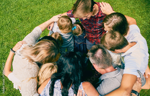 Family of eleven standing embracing in circle