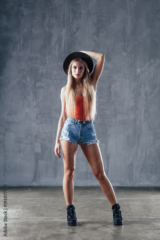 Fototapeta premium Young beautiful female dancer is posing in the studio
