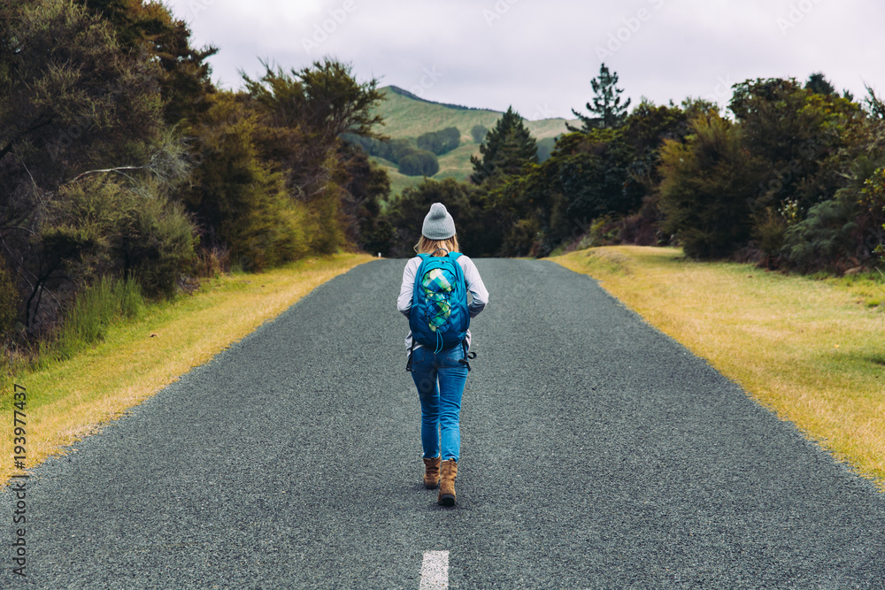 One woman backpacking alone on a road 