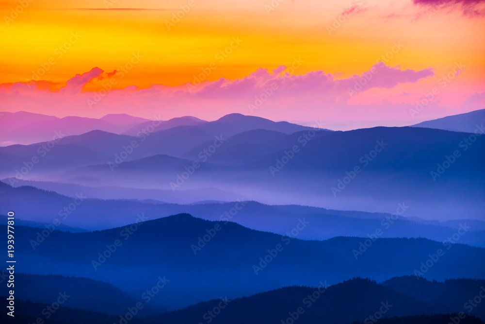 quiet mountain valley in a blue mist at the sunset