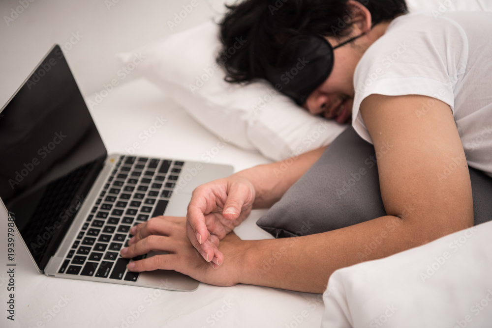 Asian man is sleeping on the bed in bedroom leave his work on computer. Asian man is sleeping on the bed in bedroom leave his work on computer.