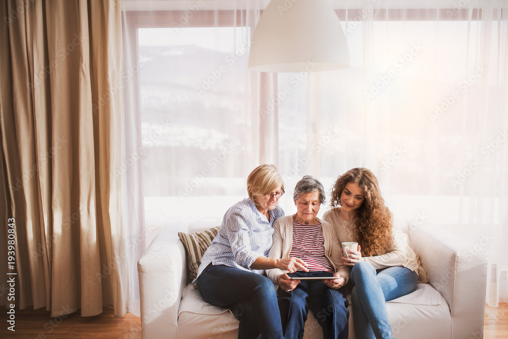 A teenage girl, mother and grandmother with tablet at home. A teenage girl, mother and grandmother with tablet at home.