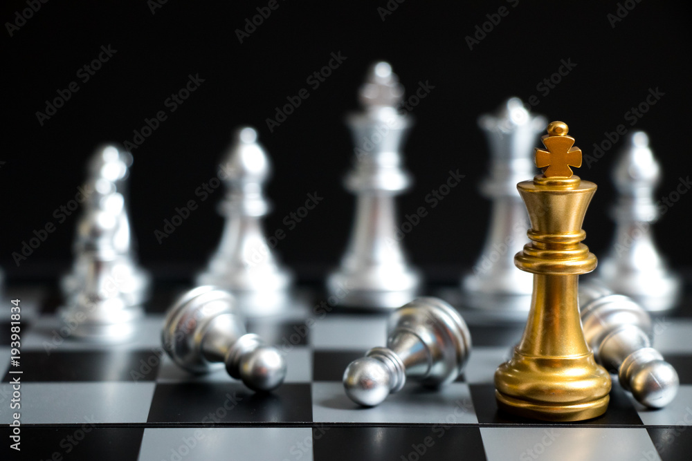Gold King in chess game face with the another silver team on black background (Concept for company strategy, business victory or decision) Gold King in chess game face with the another silver team on black background (Concept for company strategy, business victory or decision)