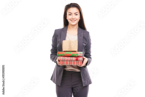 Portrait of young Asian businesswoman giving you stack of gifts