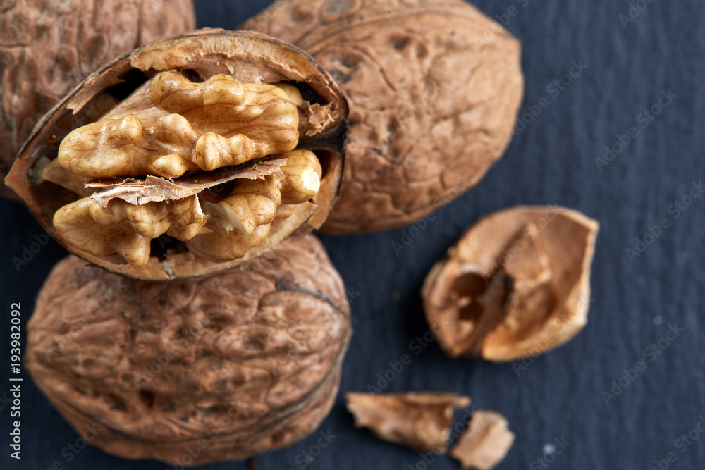 Top view close-up shot of cracked walnuts on dark background, shallow depth of field, macro Top view close-up shot of cracked walnuts on dark background, shallow depth of field, macro