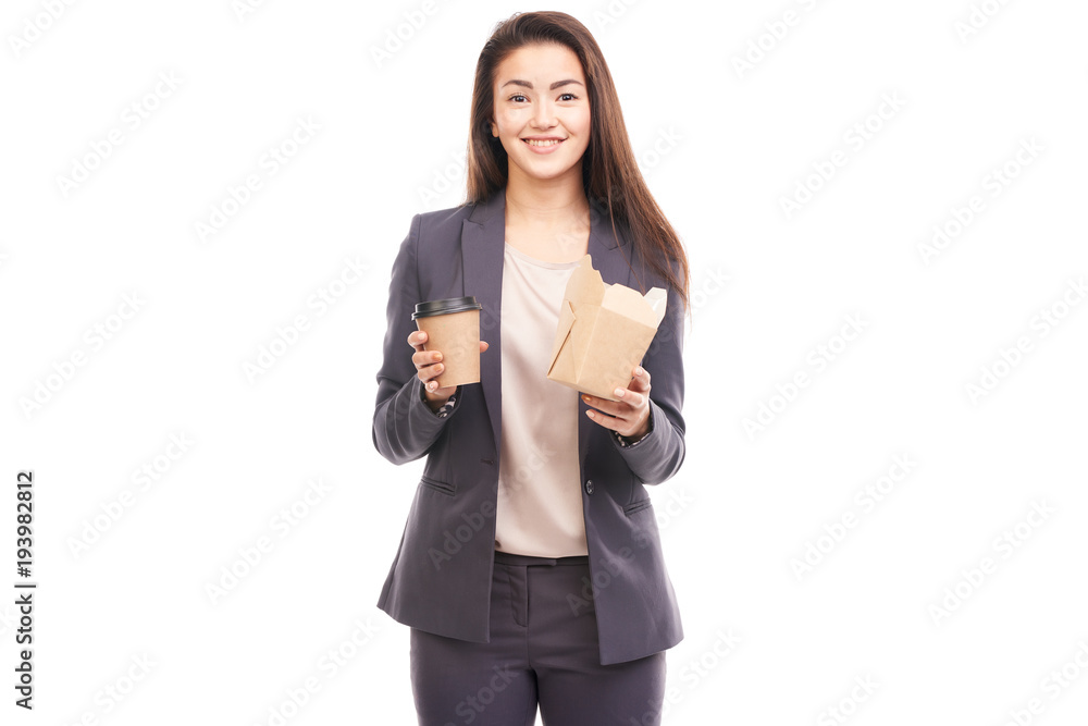 Young businesswoman eating take-away food and drinking from paper coffee cup Young businesswoman eating take-away food and drinking from paper coffee cup