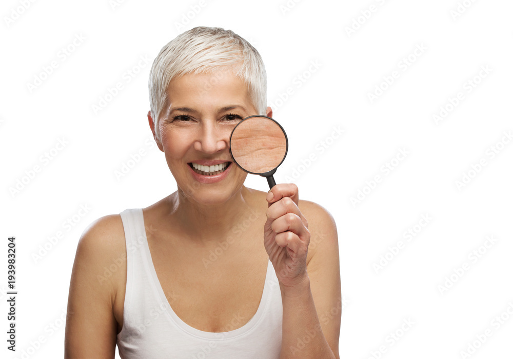Portrait of a beautiful elderly woman holding a magnifying glass, isolated on white background Portrait of a beautiful elderly woman holding a magnifying glass, isolated on white background