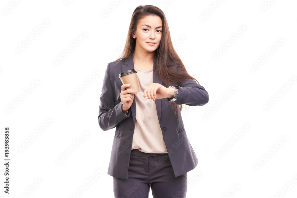 Young female office worker holding paper coffee cup and checking time Young female office worker holding paper coffee cup and checking time