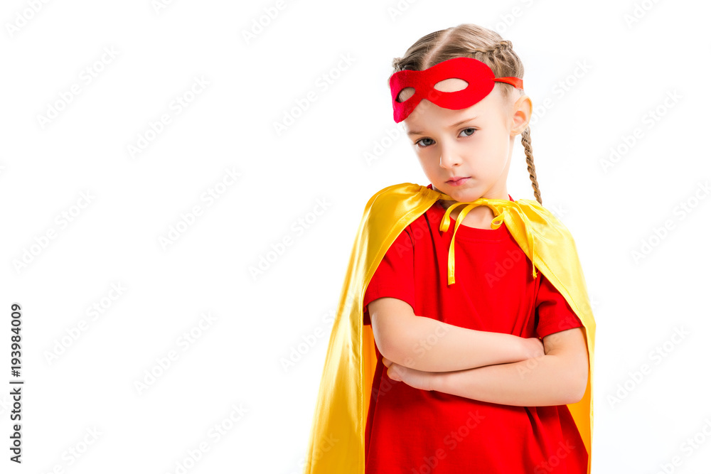 Grumpy little supergirl wearing yellow cape with red mask for eyes on forehead isolated on white