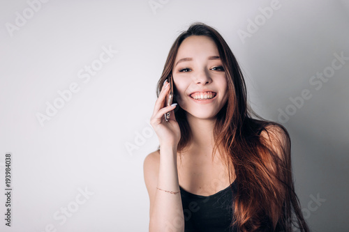 Girl calling on phone at home. Happy woman uses a smartphone