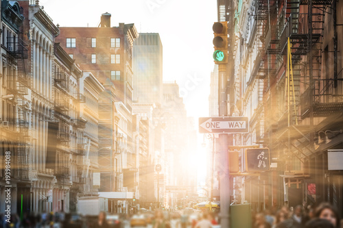 Sunlight shines on people walking the streets of SoHo in New York City
