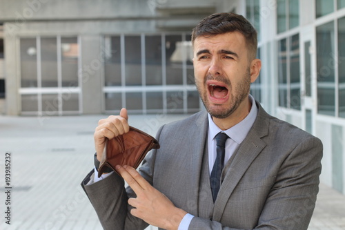 Businessman crying holding his empty wallet