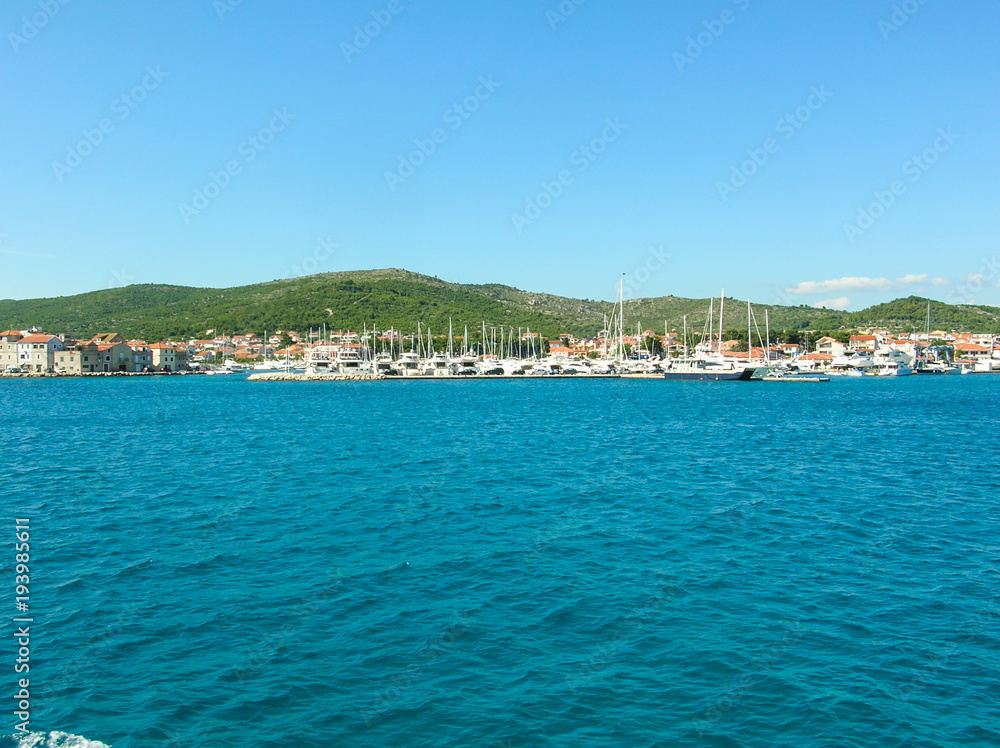 Boating Lifestyle. Boats docked in a marina with a rocky foreground and the beginning of a sunset in the background. Boating Lifestyle. Boats docked in a marina with a rocky foreground and the beginning of a sunset in the background.