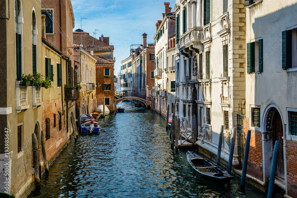 An old canal in Venice with boats parked near entrances of residential buildings