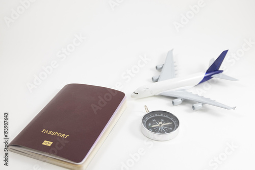 white background passport, comprass and model plane placed on white floor with copy space. image for business, document, isolated, travel, person, identification, holiday, tourist concept photo